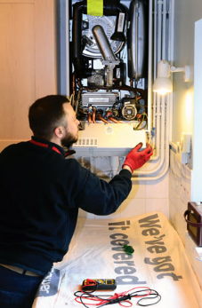 Homelife image of man repairing boiler Homelife image of man repairing boiler
